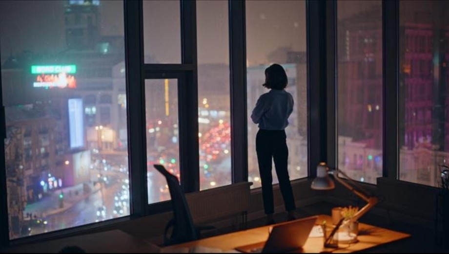 Ejecutiva contemplando la ciudad — claridad y decisión bajo presión